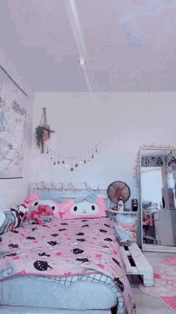 a girl with pink hair and a pink bow on her head is holding a stuffed animal .