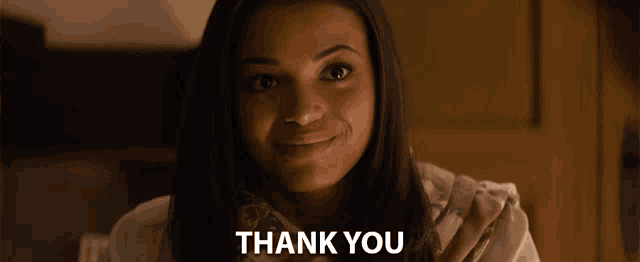 a woman is smiling in front of a thank you message
