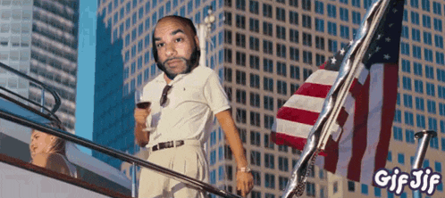 a gif of a man holding a glass of wine with the words gif jif on the bottom