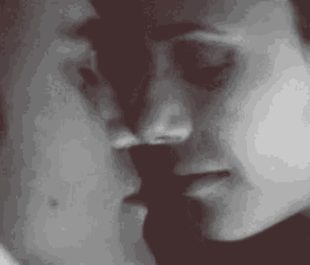 a close up of a man and woman kissing each other .