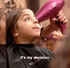 a young girl is getting her hair blow dried by a hairdresser and says it 's my decision .