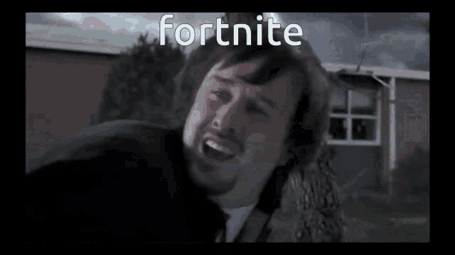 a man with a beard is standing in front of a building with the word fortnite written on it