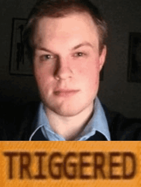 a man 's face is behind a yellow sign that reads triggered
