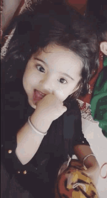 a little girl is sticking her tongue out while laying on a bed