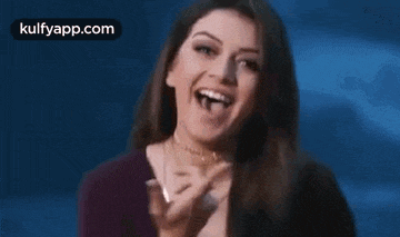 a close up of a woman laughing with her mouth open and her tongue out .