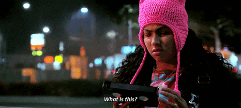 a woman in a pink hat is holding a gun and asking " what is this "