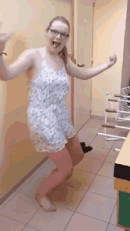 a woman in a dress is dancing in a hallway with her arms outstretched .