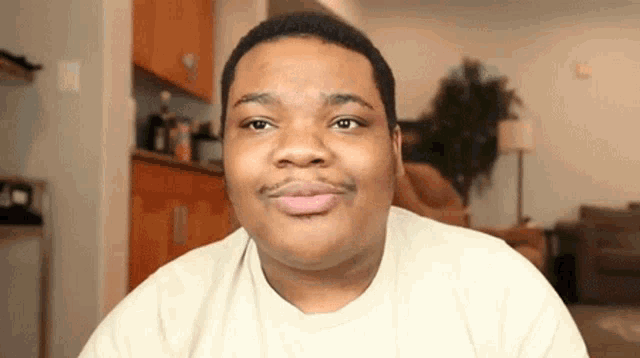a man with a mustache is making a funny face while looking at the camera .