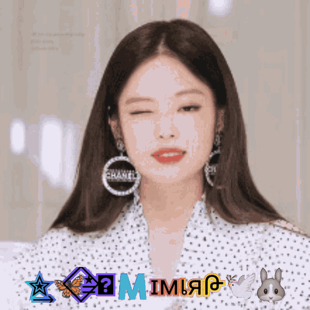 a woman wearing a pair of chanel earrings is winking
