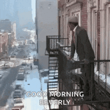 a man in a suit is standing on top of a fire escape .