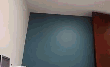 a person is standing in a room with a blue wall .