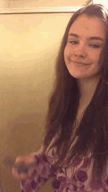 a young woman with long hair is standing in front of a mirror .