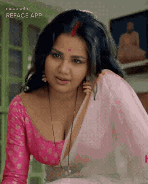 a woman is wearing a pink top and a white saree