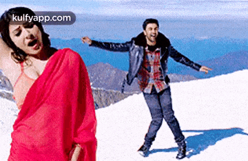 a man and a woman are dancing on a snowy mountain .