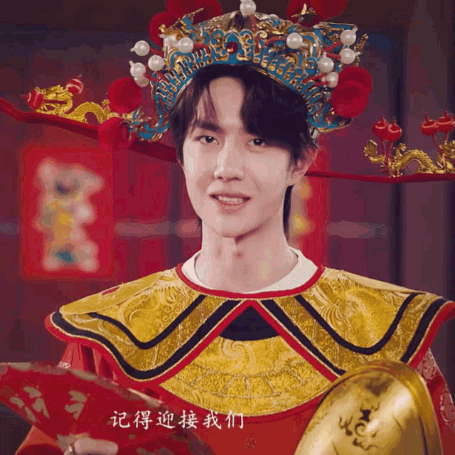 a man is wearing a crown and holding a fan with chinese writing on it