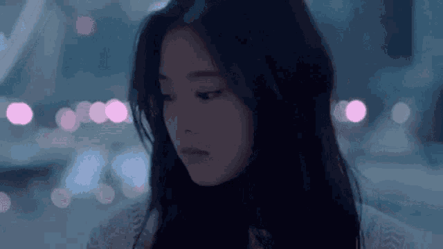 a close up of a woman 's face with a blurry background and a city in the background .