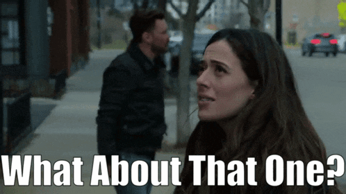 a man and a woman are standing on a sidewalk and the woman is asking what about that one