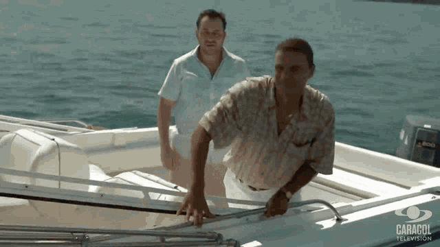 two men standing on a boat with caracol television written on the bottom