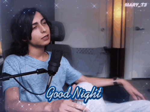 a man sitting in front of a microphone with the words good night written below him
