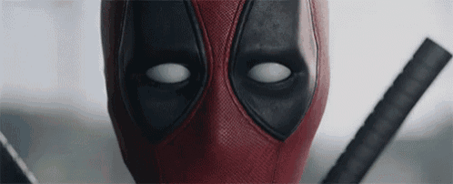 a close up of deadpool 's face with white eyes and a sword