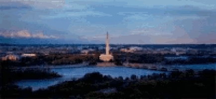 a blurry picture of a city with a statue in the middle of it