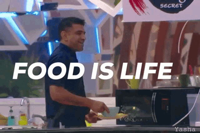 a man standing in front of a microwave with the words food is life written above him