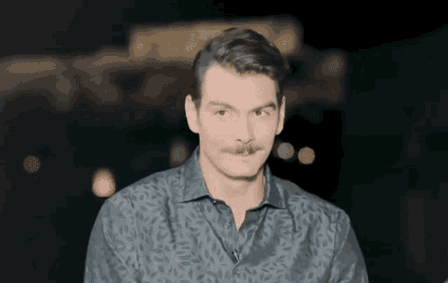 a man with a mustache is making a funny face