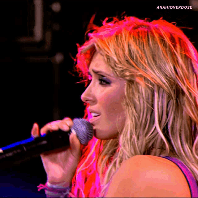 a close up of a woman singing into a microphone with the hashtag amahioverdose on the bottom