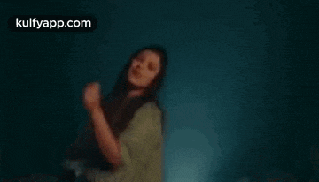 a woman is dancing in a dark room in a blurry photo .