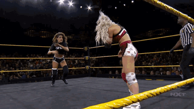 two women in a wrestling ring with the word nxt on the ropes