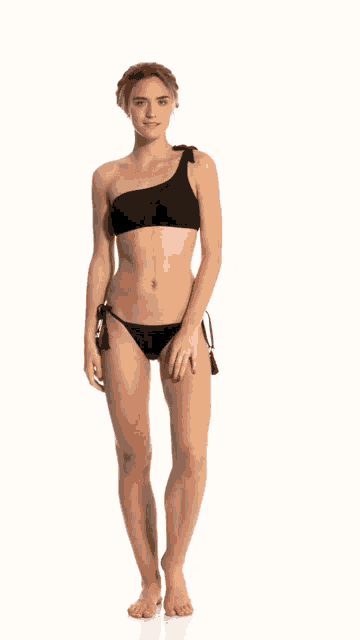 a woman in a black bikini is standing on a white surface