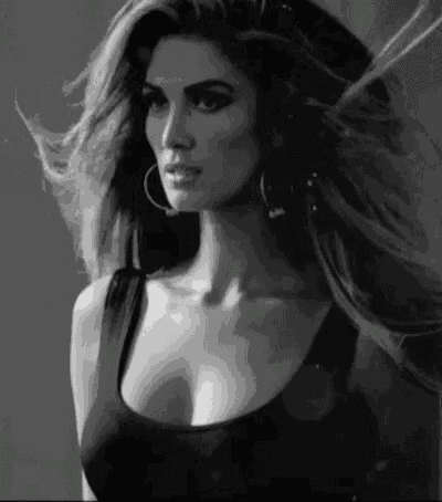 a black and white photo of a woman with long hair and hoop earrings .