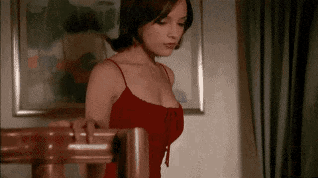 a woman in a red dress is standing on a staircase