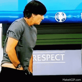a man in a grey shirt stands in front of a sign that says respect