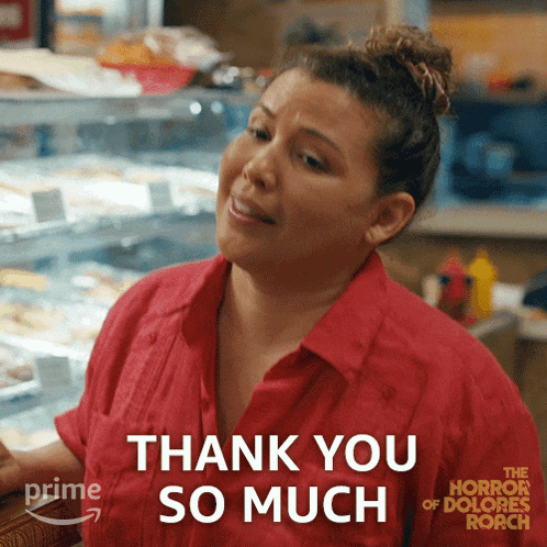 a woman in a red shirt is sitting at a counter and says thank you so much