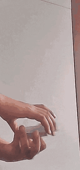 a close up of a person 's hand holding a piece of glass .