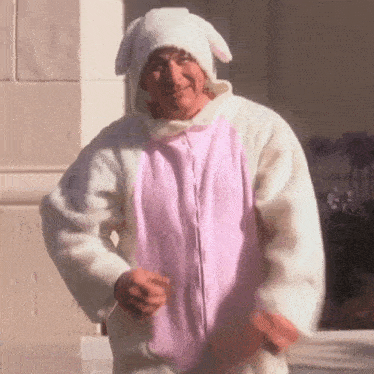 a man is wearing a pink and white bunny costume and a white hat .