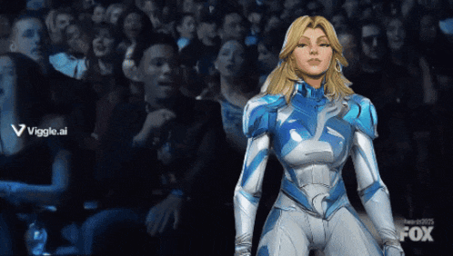a woman in a blue and white superhero suit is standing in front of a crowd with the fox logo in the corner