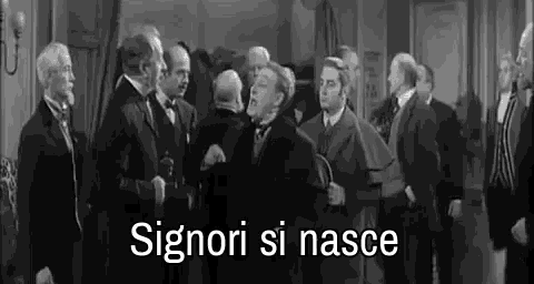 a black and white photo of a group of men standing in a room with the words signori si nasce written in white .