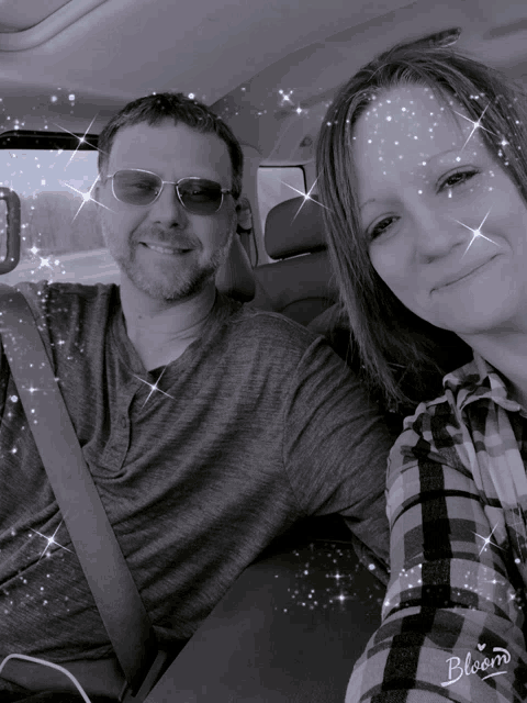 a black and white photo of a man and a woman in a car with bloom written on the bottom