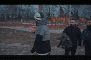 a man in a helmet talks to two other men