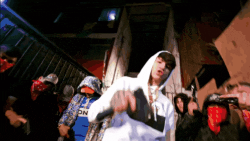 a man wearing a white hoodie with the letter l on it stands in front of a crowd
