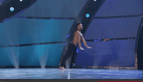 a man without a shirt is dancing on stage