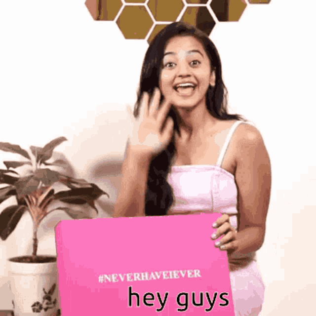 a woman holding a pink box that says " hey guys " on it