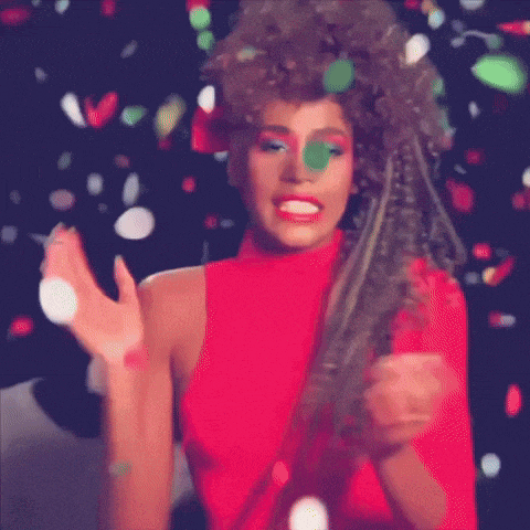 a woman in a red top is standing in front of confetti falling around her