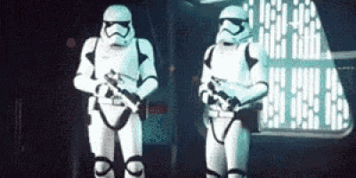 two stormtroopers are standing next to each other in a room .