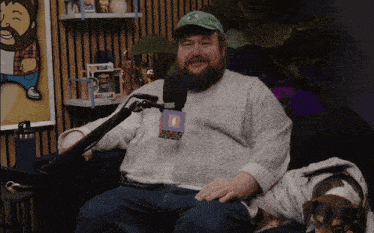 a man with a beard is sitting in front of a microphone with a tag that says ' a '