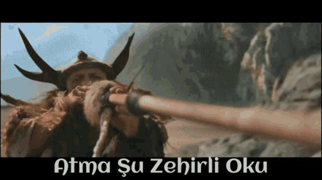 a man with horns is holding a stick in front of a mountain and the words attma su zehirii oku