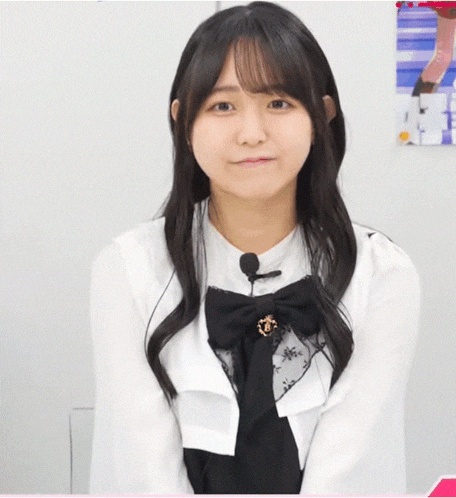 a girl wearing a white shirt with a black bow