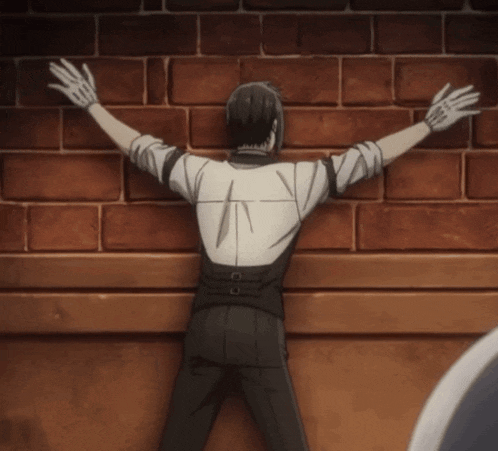 a man with his arms outstretched is leaning against a brick wall